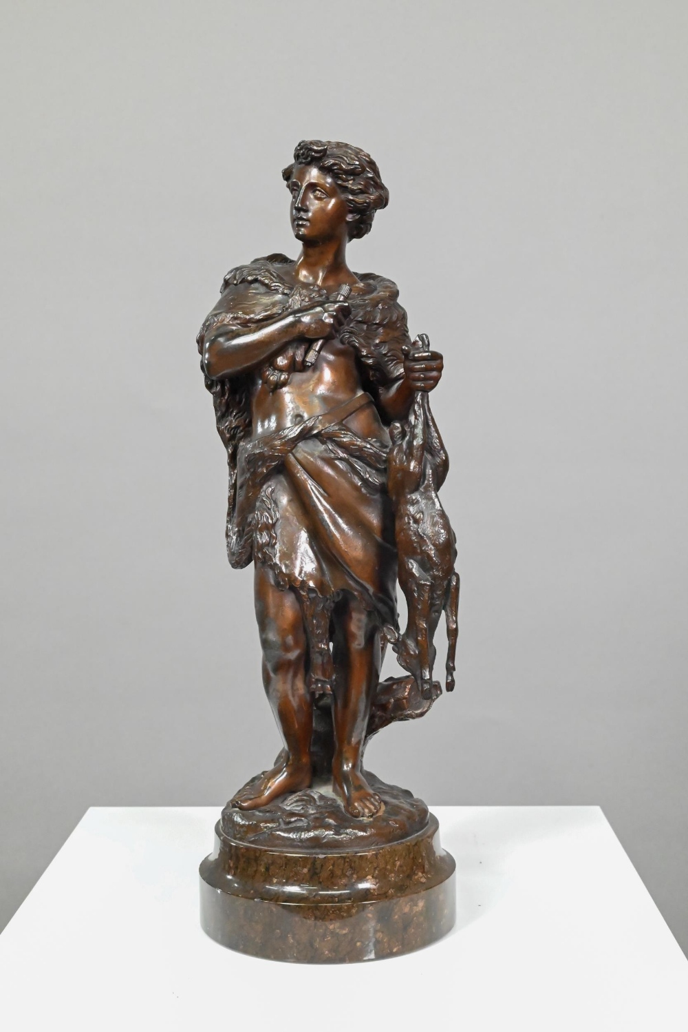 Emile Boyer (1877 - 1948), a brown-patinated bronze sculpture of a huntsman in wolf-skin cloak,