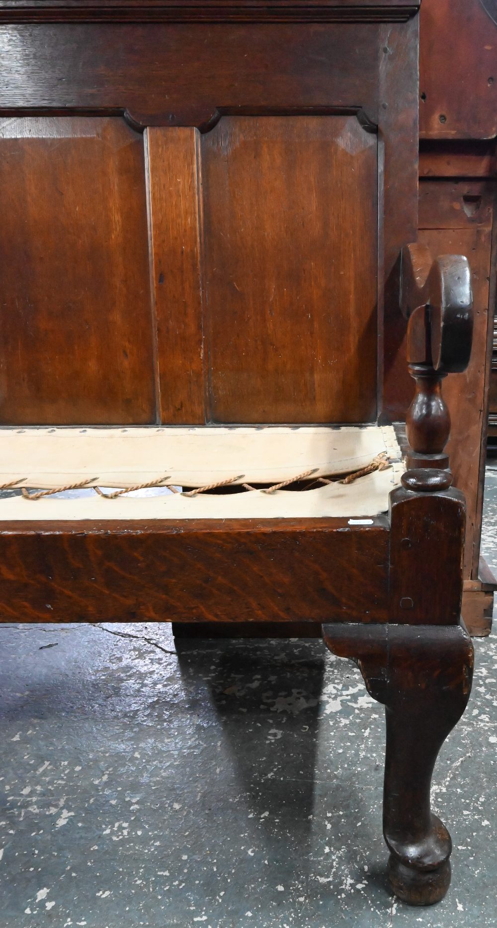 An 18th century oak panel backed settle, with shaped arms over a rope and canvas seat (cushion - Image 4 of 6