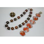 A moss agate bracelet formed of chain-linked oval discs, a Victorian piqué work brooch and a row