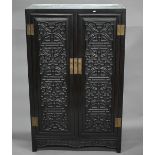 An early 20th century Chinese ebonised carved hardwood wood cabinet, the twin doors with shou