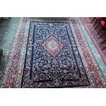 A fine Persian handmade Kashan carpet, the floral vine design on cream ground centred by a blue