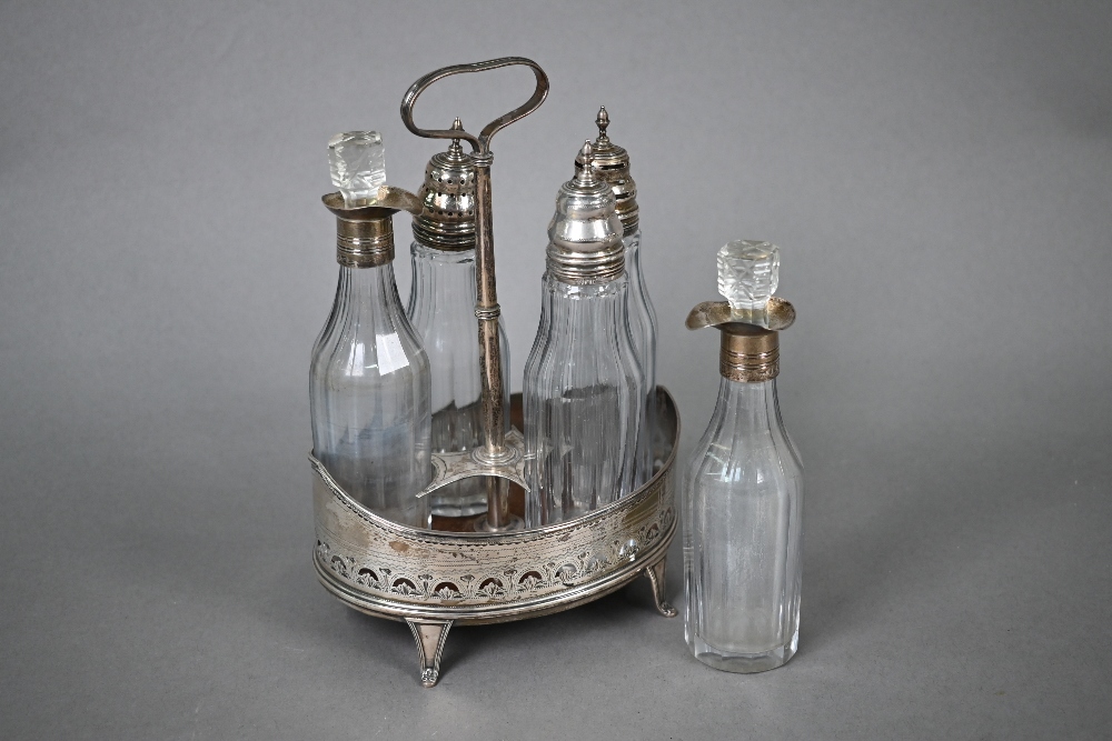 George III oval silver cruet with wooden platform, engraved and pierced sides and scroll feet,