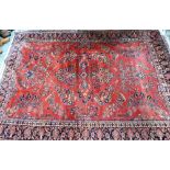 An antique Persian Mohajeran - Sarouk carpet, the dark salmon ground with overall floral design, 353
