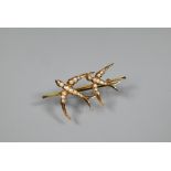 A Victorian 9ct yellow gold bar brooch with two flying swallows with outstretched wings, set overall
