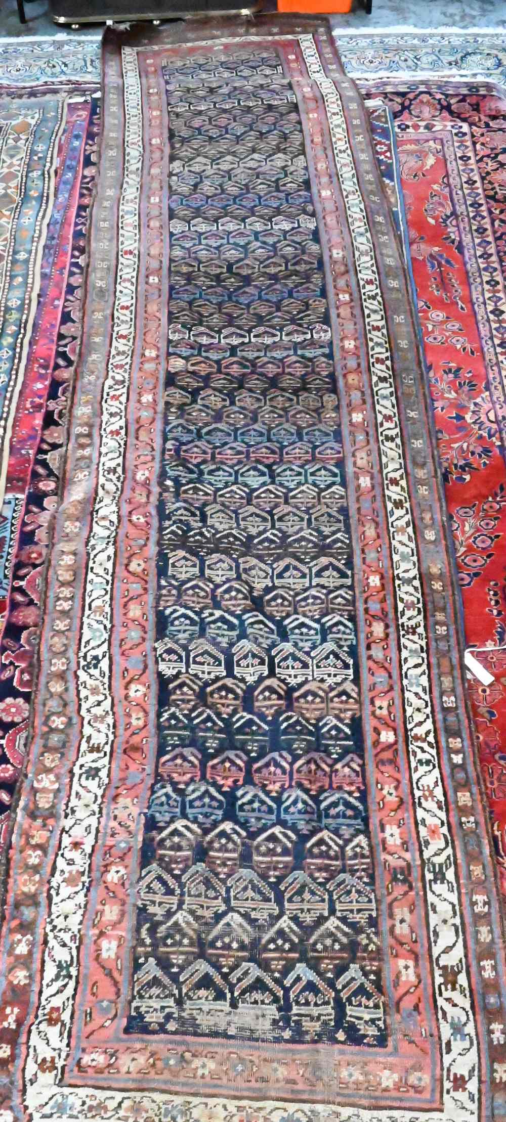 An antique Persian Kurd runner, the ink blue ground with repeating rows of stylised boteh, 417 cm  x