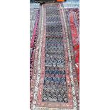 An antique Persian Kurd runner, the ink blue ground with repeating rows of stylised boteh, 417 cm  x