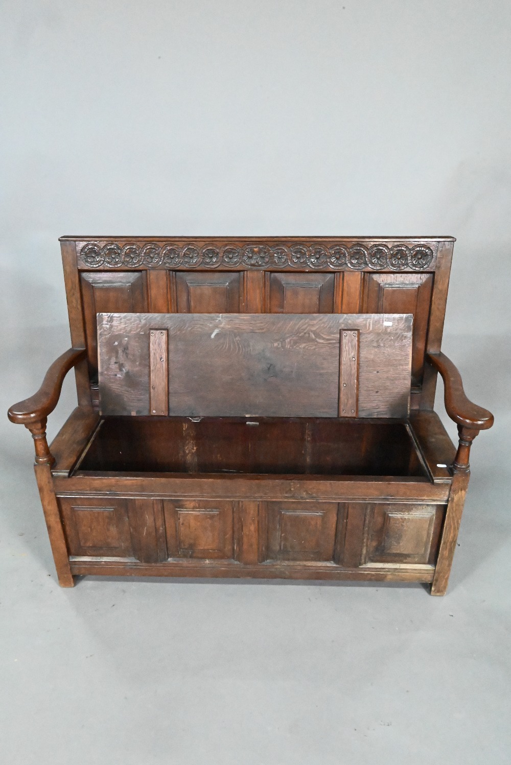 An antique oak box settle, the panelled back with floral carved rosette's over shaped arms and an - Image 2 of 6