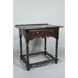 A 17th century style provincial oak side table, with single frieze drawer, raised on turned legs