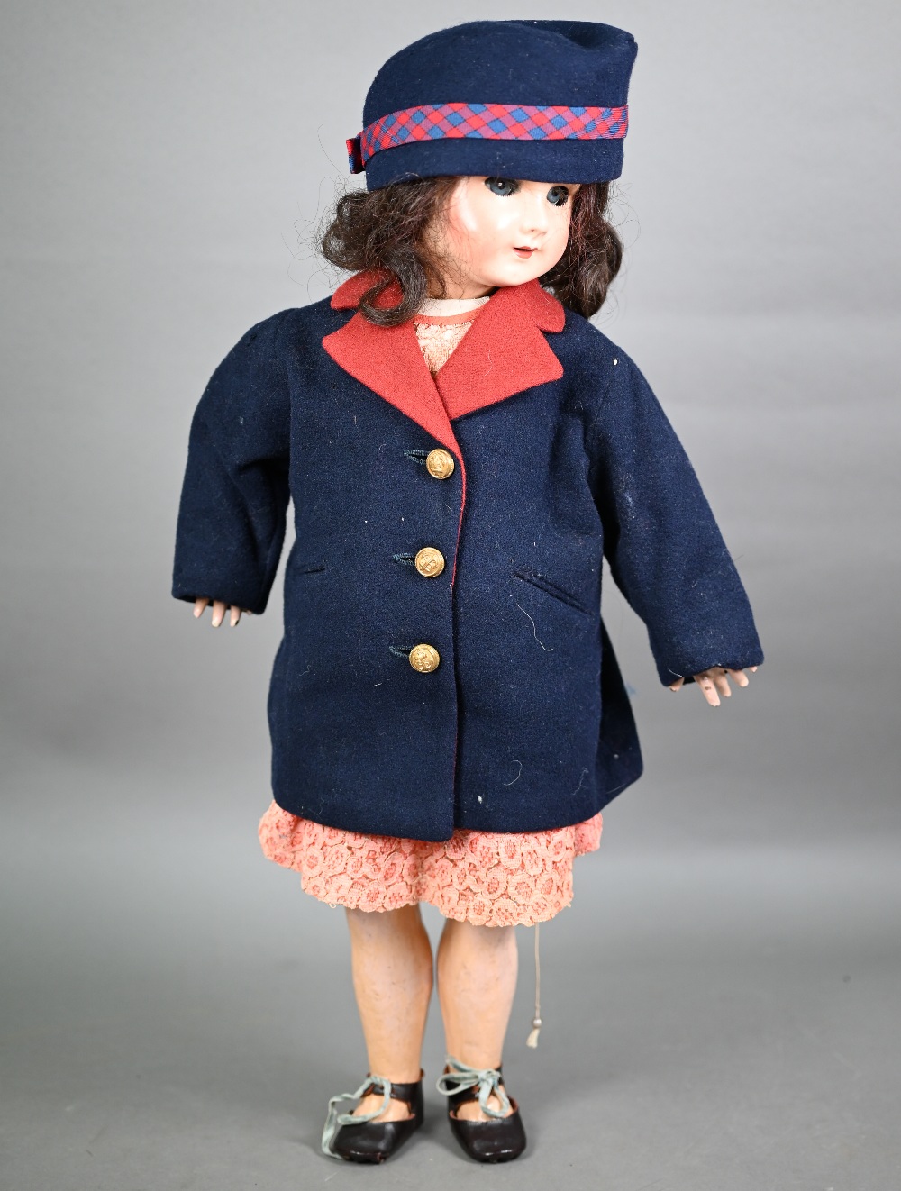 A 1920s composite girl-doll, dressed in tailored Naval jacket. 59 cm