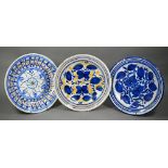 Two Delft polychrome floral-design chargers and a blue and white example (two signed with initials