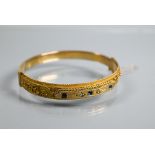 An Edwardian 9ct yellow gold bangle of oval half-hinged form, with applied bead and rope-style