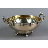 Arts & Crafts planished silver gilt bowl with twin handles, on four claw feet, Wakeley & Wheeler,