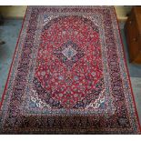 A Persian Kashan red ground carpet, with traditional stylised floral design, 348 cm x 248 cm