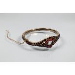 A Victorian half-hinged bangle set overall with garnets (possibly), silver-gilt, in as found