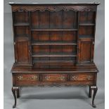 An 18th century style oak high dresser, the rack with dentil moulted canopy centred by open