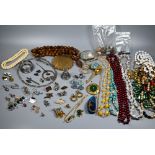 A collection of jewellery including beads, necklaces, earrings, brooches, compact, silver napkin