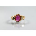 A three stone ring, the central oval cabochon ruby with circular diamond to each side, claw set,