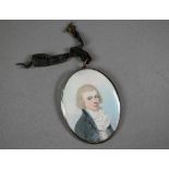 A Georgian oval portrait miniature on ivory of a young gentleman, circa 1790, with extravagant