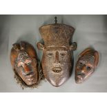 Two Oceanic carved wood masks with copper sheet and wire mounts, 28/24 cm, to/w another mask with