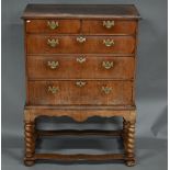 An 18th century walnut chest on stand, with two short over three long graduated drawers with brass
