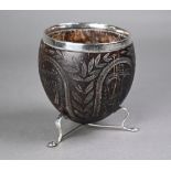 An 18th century coconut cup with later ep rim and feet, carved with Crown, Roses, Thistles and Harp,