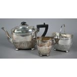 Victorian silver three-piece bachelor tea service of half-fluted oblong form, on bun feet, Martin,