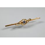 An Edwardian bar brooch set with four small seed pearls and blue stone, yellow metal set stamped