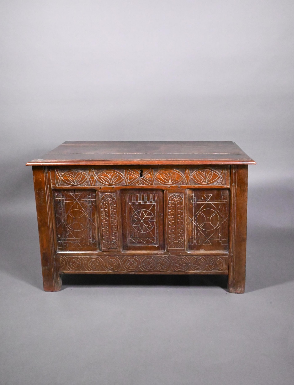 An early 18th and later oak coffer, with lunette carved frieze over a trio of incised panels, on