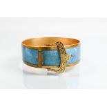 A gilt metal and turquoise enamel bangle in the form of a buckle with stylised 'spider web' enamel