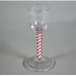 A Georgian cordial glass cut with intertwined foliated guilloches, on red/white opaque triple-