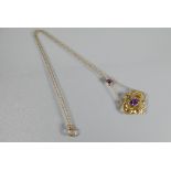 An Art Nouveau pendant, the 9ct yellow gold open scroll design with central oval shaped amethyst,