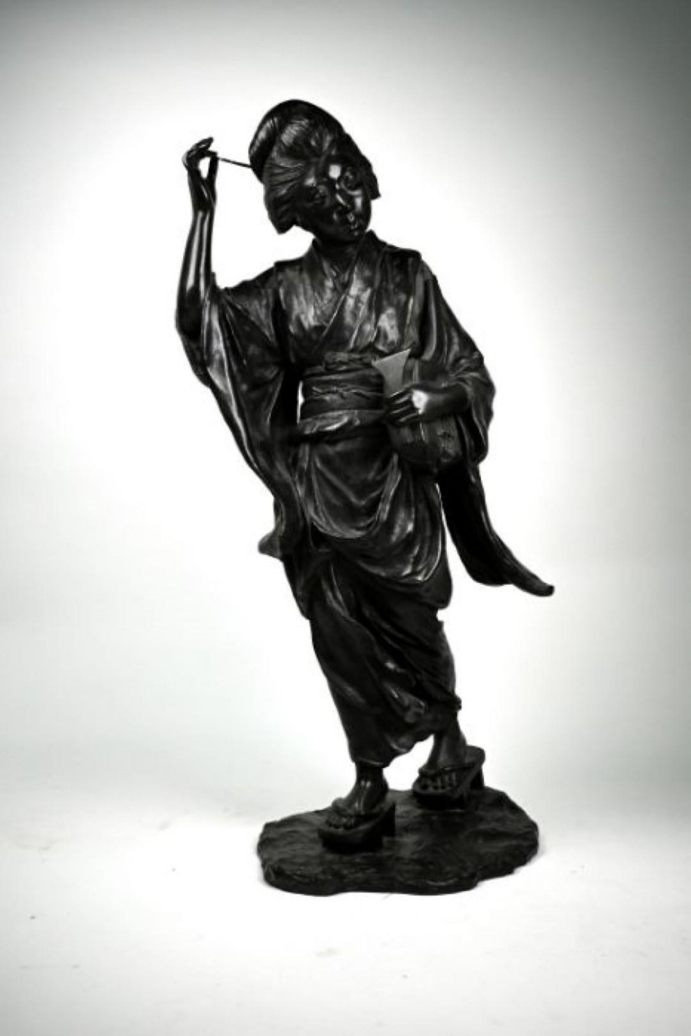 A large late 19th century Japanese bronze okimono of a Geisha by Genryusai Seiya, cast wearing a - Image 2 of 5