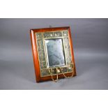 An Arts & Crafts brass twin girandole mounted mirror, the bevelled plate within intricate relief