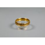 A 22ct yellow gold wedding band with incised decoration, size L 1/2, approx 3.7g