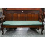 An 18th century oak panel backed settle, with shaped arms over a rope and canvas seat (cushion