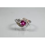 A ruby and diamond ring, the central ruby with a diamond to each side in crossover setting, with