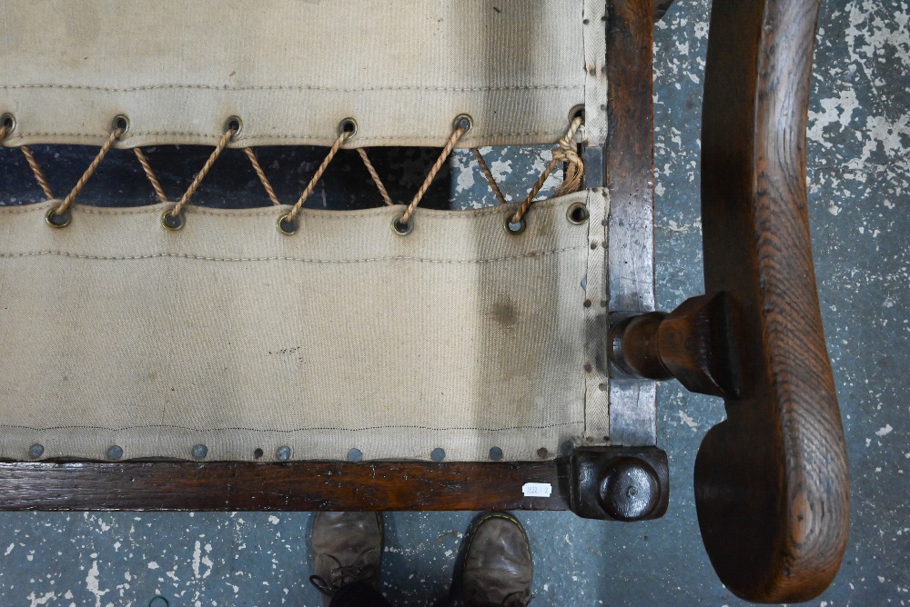 An 18th century oak panel backed settle, with shaped arms over a rope and canvas seat (cushion - Image 5 of 6