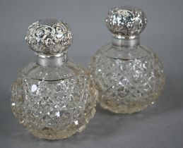 Pair of Edwardian cut glass globular scent bottles with embossed silver screw bun covers, Birmingham