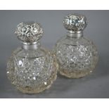 Pair of Edwardian cut glass globular scent bottles with embossed silver screw bun covers, Birmingham