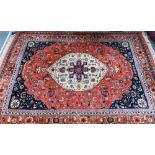 A hand-made Persian Heriz carpet, centred by a camel ground oval tablet on salmon-red ground, 347 cm
