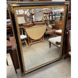 A large modern gilt and ebonised wall mirror of rectangular form