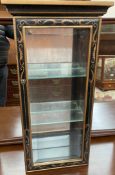 A modern ebonised and gilt decorated table top display cabinet with a mirrored back and two glass