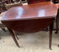 A 19th century mahogany Pembroke table with an oval top with drop flaps above a frieze drawer on