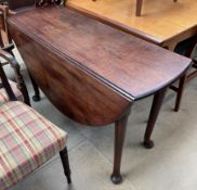 A 19th century mahogany drop leaf dining table with drop flaps and an oval top on tapering legs and