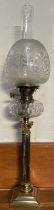 A brass and faceted clear glass oil lamp, with an etched glass shade,