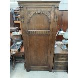 A 20th century oak hall robe with a carved door, 80cm wide x 181cm high x 52.