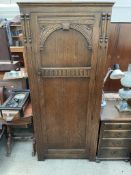 A 20th century oak hall robe with a carved door, 80cm wide x 181cm high x 52.