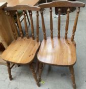 A pair of pine kitchen chairs together with a pine kitchen table