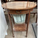 An Edwardian mahogany work table with an oval top above a sectional drawer and pull out slide on