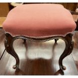 A continental mahogany stool with a shaped pad upholstered seat on scrolling legs